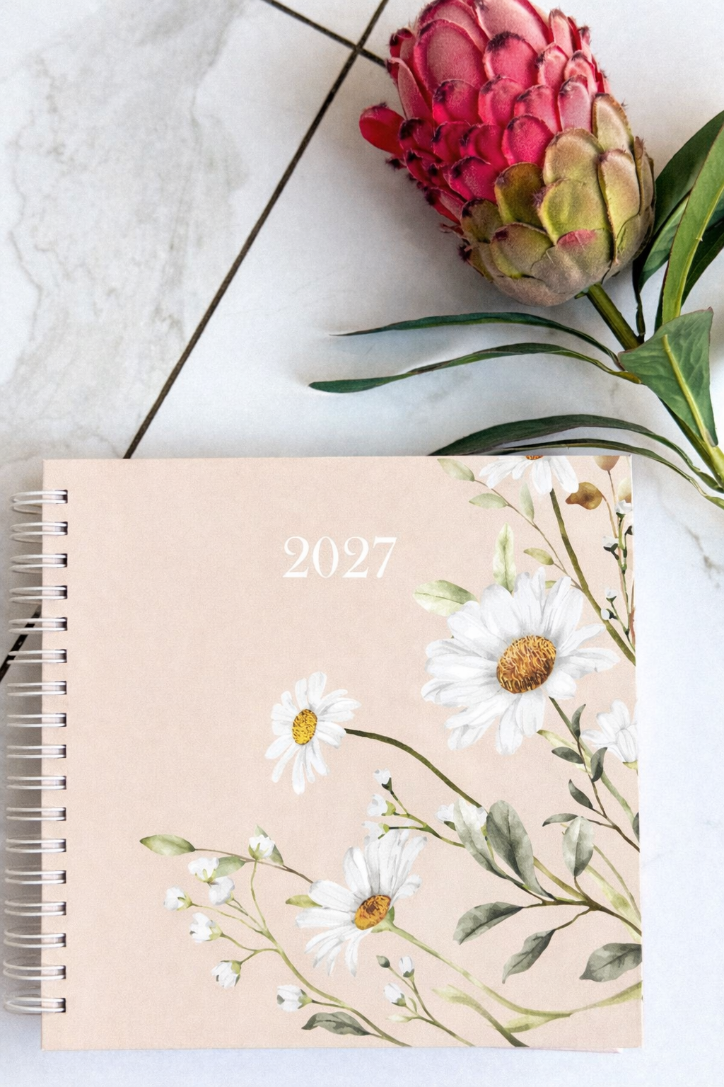 Floral design diary  for 2027 with protea flower on marble surface